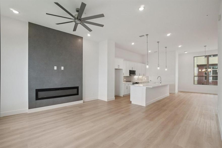 Newly completed, designer-finished townhome offering clean lines, modern luxury, and effortless style. Premium luxury vinyl plank flooring runs throughout, paired with sleek designer tile in the bathrooms and utility areas for a polished, contemporary look. The open-concept main living level impresses with 11-foot ceilings, oversized windows allowing an abundance of natural lighting. Stunning kitchen is anchored by a 12-foot quartz island, soft-close custom cabinetry, and modern hardware. The living area is elevated by a 72-inch horizontal fireplace, delivering both style and warmth. Goodland Townhomes is an exclusive, contemporary community of just 25 three-story luxury residences, thoughtfully designed for modern urban living. Prime location, just minutes from downtown Farmers Branch, this evolving area offers walkable access to restaurants, Cox Farms Market, and the DART Train system, parks, jogging & bike trails, and so much more! Photos are representative; finishes may vary by unit.