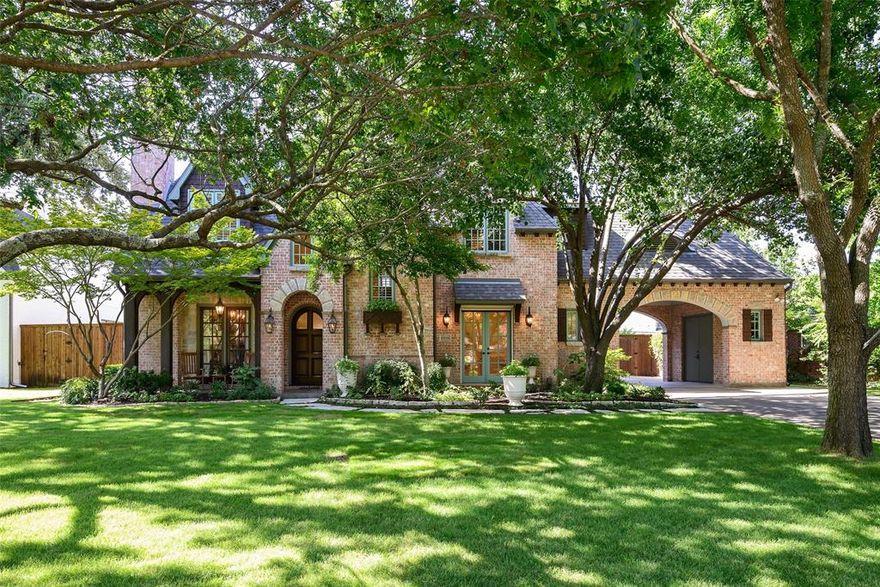 Tucked beneath majestic oak trees in the heart of Preston Hollow, this one-owner custom residence by Registry Fine Homes showcases timeless architecture, refined finishes, and a premier location just minutes from the prestigious St. Mark’s School of Texas and other top rated private schools. Designed for both elegant entertaining and everyday living, the intelligent floor plan features a spacious first-floor primary suite, private study, and abundant storage throughout—all adorned with elegant touches like crystal chandeliers and vaulted ceilings. The open-concept gourmet kitchen is a chef’s dream, boasting dual sinks, a center island, and Viking appliances, including a built-in refrigerator, 6-burner cooktop, double ovens, warming drawer, and built-in microwave. Filled with natural light from the many large windows, the living areas flow seamlessly to a screened-in back porch, offering an indoor-outdoor living experience. The serene primary suite includes a cozy sitting area and a luxurious ensuite bath with dual vanities, spa-like soaking tub, oversized shower, and expansive walk-in closet. Upstairs offers three additional bedrooms, a versatile game room with raised stage, a dedicated exercise room, and a large walk-in attic for storage or future “dream space” expansion of a potential 5th bedroom suite. The private backyard is a true retreat, with lush Zoysia grass and a sparkling pool featuring cascading sheer-descent waterfalls. Extensively updated from 2021–2025, notable improvements include a reimagined kitchen and primary bath (2021), pool and landscaping upgrades (2021), and a new roof (2023). The three covered parking spaces include an oversized 2.5-car garage plus additional covered parking under the porte-cochere and a parking pad. With direct access to the Northaven Trail, the Private School Corridor, NorthPark Center, and both Love Field and DFW airports, this meticulously maintained home offers an unparalleled blend of luxury, comfort, and location.