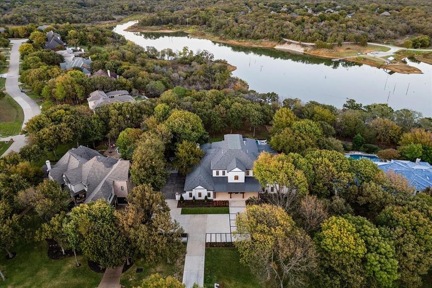 Nestled in the prestigious gated community of Point Noble in Flower Mound, this stunning 1.13-acre waterfront property offers breathtaking views of Lake Grapevine. Located in a quiet cul-de-sac, this move-in-ready estate was extensively renovated in 2021 and 2022, boasting high-end improvements throughout. Step inside to find elegant herringbone wood flooring, custom cabinetry, upgraded windows and doors, an advanced AV system, designer lighting, and more. The heart of the home is a chef’s dream kitchen featuring Sub-Zero and Wolf appliances, dual dishwashers, a workstation with Brizo faucets, hidden refrigerator drawers, and a butler’s pantry. A third-story loft offers scenic lake views, adding a serene touch to this remarkable residence. The backyard is an entertainer’s paradise with an outdoor kitchen, covered patio, and infinity-edge pool overlooking the tranquil yard. This home perfectly blends sophisticated design with a relaxed lifestyle.