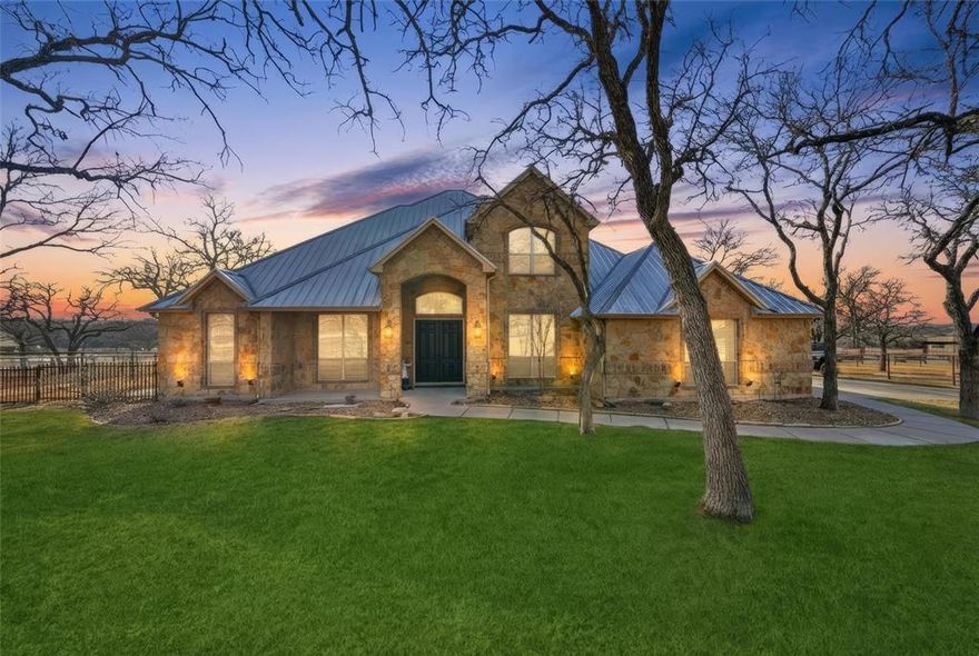 Experience luxury living in the exclusive Silverado on the Brazos community. Set on 4.889 acres, this beautifully updated two-story home offers 4 bedrooms, 3 bathrooms, and an office. The formal dining area flows into a spacious living room with a custom stone accent wall and electric fireplace. The kitchen is thoughtfully designed with quartzite countertops and contemporary finishes. The private primary suite features a spa-inspired soaking tub, sleek glass-enclosed shower, and spacious walk-in closet. Step outside to a shaded patio overlooking a sparkling pool with a waterfall, perfect for relaxing or entertaining. The 36’ x 114’ barn is an equestrian dream, boasting three interior Classic Equine European 12x12 custom stalls with stall mattresses and covered runouts, plus two covered exterior stalls, and rubber horse barn pavers throughout. The barn, shop, and apartments are spray-foam insulated and freshly painted, and a brand-new 24’ x 10’ loafing shed has been added. The barn includes a brand-new guest space with a full bathroom. Additional barn amenities include a workshop, tack room, feed room, and ample covered parking for trailers, feed, or farm equipment. The property also features new custom pipe fencing throughout. Equestrian amenities include four paddocks and a round pen, along with two covered RV hookups (50-amp and 30-amp). There is community access to the Brazos River, creating a rare combination of luxury living, equestrian functionality, and peaceful country surroundings.