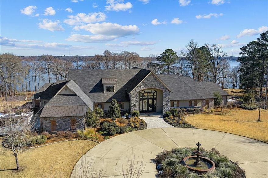 Discover an extraordinary lakefront sanctuary on the breathtaking shores of Caddo Lake. This private, gated 5-acre luxury estate captures unmatched sunrise and sunset views, offering the ultimate blend of elegance, recreation, and serenity. The magnificent custom-built main residence built of Brick and Custom Candian Granite is 7557 of outdoor living and patios with 5064 within the home, the guest home is 2027 under roof and 1606 heated and cooled with 2 car carport, and Shop 1375 sq ft with 15 foot ceilings for all your storage needs!  The main residence entry showcases soaring cathedral ceilings, expansive walls of glass, and a grand stone fireplace anchoring the open-concept living space. Designed for refined entertaining, the chef’s island kitchen features top-tier appliances, bespoke cabinetry, generous pantries, a butler’s pantry, wet bar, and an impressive 800 plus bottle climate controlled wine cellar. The owner’s retreat is a true spa experience with dual vanities, soaking tub, multi head walk through shower, and oversized closets with private laundry access. A custom office off the owners suite and GYM, dog bathing room, utility room, two pantries, Upstairs, a game or media lounge with built-in bunk accommodations welcomes guests in style Outdoors, enjoy resort-style amenities including a sparkling pool, firepit gathering space, custom playground, and a spectacular dock with three boat slips and entertaining deck.  There is even a complete play yard for the kids!  Completing the estate is a second beautifully appointed 3-bedroom guest home with separate parking and exceptional income potential and the shop!  All with electric gate at the road for privacy and your own private drive.  A rare opportunity to own a one of a kind luxury waterfront compound. Numerous extra photos and video available.  A private tour available from your favorite realtor or welcome call me today for more information.  Caddo Magnet Schools Avail- Virtual tour availalble for guest hm