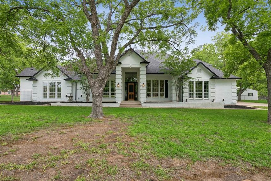 Experience resort-style living in this exceptional estate nestled on 3.36 fenced acres within the highly sought-after gated community of Pecan Plantation. Surrounded by mature pecan trees and peaceful natural scenery, this remarkable property offers more than 7,300 square feet of thoughtfully designed living space where luxury, comfort, and functionality come together seamlessly. This expansive 4-bedroom, 4.5-bath residence features two stunning primary suites, including a spa-inspired retreat with a soaking tub, oversized walk-in shower, and remote-controlled electric shades for added privacy and convenience. A richly detailed executive office with custom wood finishes and a dramatic accent ceiling creates the perfect environment for working from home or quiet relaxation. At the center of the home is a beautifully designed chef’s kitchen complete with quartz countertops, double ovens, induction cooktop, abundant cabinetry, and an open-concept design that flows effortlessly into the spacious living areas. Floor-to-ceiling windows fill the home with natural light while showcasing the surrounding landscape. The standout feature of this estate is the incredible indoor pool retreat — a private year-round oasis designed for entertaining and relaxation. Accessible directly from the main living space, this climate-controlled area includes its own full kitchen, bathroom, fireplace, and dedicated dehumidification system, creating the ultimate indoor resort experience. Additional highlights include a spacious 3-car garage, energy-efficient solar panels, and a large utility room complete with a custom dog washing station. Equestrian enthusiasts will appreciate the 2-stall horse barn, while community amenities offer endless recreation including golf, tennis, marina access, parks, trails, clubhouse facilities, and more. This one-of-a-kind estate delivers an unmatched blend of luxury living, privacy, and premier community amenities in one extraordinary property.