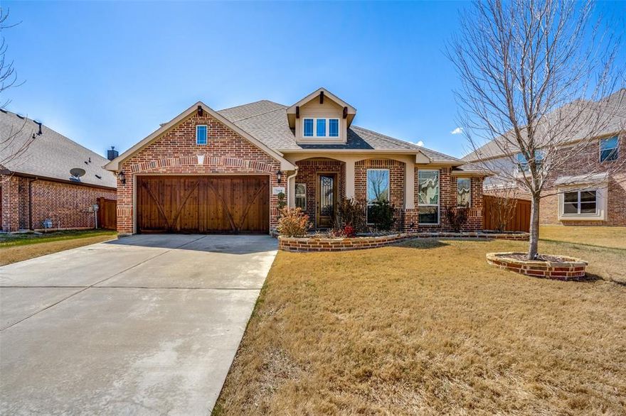 Stunning Home in the Mira Lagos Community Las Brisas. This beautiful home in the sought-after Mira Lagos community offers an open-concept design, perfect for entertaining. The spacious kitchen features a large island, custom cabinetry, granite countertops, upgraded stainless steel appliances, and a built-in serving buffet. Wood-look tile flows throughout the common areas, adding warmth and elegance. Upstairs, you'll find a huge game room or media room with a built-in desk and a full bath. The split-bedroom layout places all bedrooms downstairs, with the fourth bedroom offering flexibility as an office. Additional highlights include granite countertops in all bathrooms, a granite desktop, cedar garage doors, and an iron-inset front door. Enjoy outdoor living with a covered patio overlooking a spacious backyard. The lot is perfectly positioned for maximum privacy. Located in the highly acclaimed Mansfield ISD, this home is a must-see!