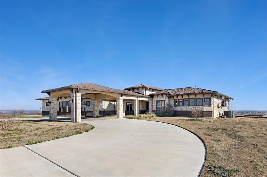 This spectacular, hill-top home on more than 17 acres offers 7844 heated and cooled living space on two levels and is built into the side of a hill that boasts panoramic views of the surrounding area. It has 4 bedrooms, each with an ensuite bath and separate seating areas in the two primary bedrooms, one for each level. On the entry level you'll discover the chef's kitchen with prep pantry, a generous living room, casual and formal dining, a full utility room with pet wash, 3 car garage, a lovely half bath, the owner's suite with a large, beautifully appointed bath and custom closet, a second bedroom also with its own bath, a dedicated office with a safe room, and other amenities including multiple crystal chandeliers and much more. It features an 8,000-sf climate-controlled shop, sparkling pool, a gorgeous casita, outdoor living and cooking...too much to list here. Call today for a private viewing of this magnificent property and make it your own!