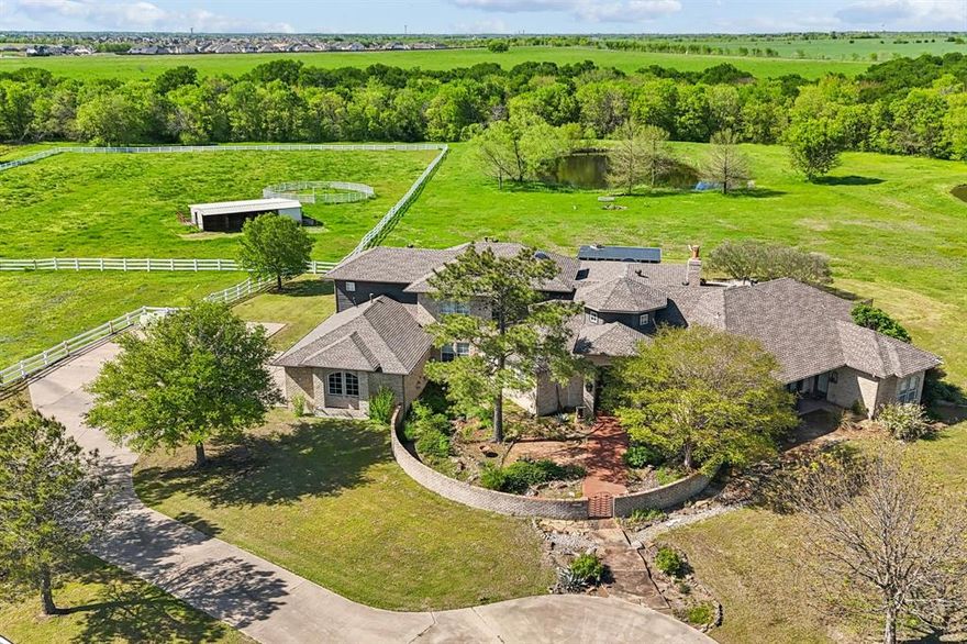 Escape the hustle & bustle and feel the peace & tranquillity of this property! If you’re looking for something unique, special & most certainly not cookie cutter, THIS is your dream property-indoors & out! This Sante-Fe style, equestrian, Ag-Exempt estate is an architectural work of art! Sante Fe not your style? Easily transform it to your style with a simple change of decor! Take the scenic road through the beautiful, gated equestrian community to the tree lined driveway to enter your sprawling 11.50acre property. The front courtyard welcomes you as you approach the custom double doors. As you step into the home, you'll notice the soaring ceilings, high windows with natural light, spaciousness everywhere, incredible architecture with custom features all around. The massive great room has beautiful wood beams & a stone fireplace. The master bedroom is huge & has its own sitting area (currently a workout area). Wake up overlooking your gorgeous backyard & acreage! The kitchen boasts a statement granite island, double ovens, built in refrigerator, ice maker, Viking stovetop & large eat-in area. There is a beautiful dining room w-real wood floors that could also be a great place for a baby grand piano! Upstairs are 2 bedrooms, a full bath & versatile bonus room *could be a 5th bedroom. Executive office and bedroom downstairs near the Primary.  The serenity of the backyard is something that has to be experienced! The arch-lined patio, beautiful garden, gorgeous diving pool & cabana w-fireplace...ALL have views of the fabulous acreage, barn with 4 stalls, pasture, stocked pond & hidden in the sea of trees at the back of the property is a creek! Invite friends & family over…there's room for all your entertaining needs, inside, out & a greenbelt thru-out neighborhood for riding horses, bikes, ATVs or walking! Guests can stay in the attached, separate entrance, guest house w-full bath & kitchenette. A truly unique retreat, perfect for daily living & entertaining!