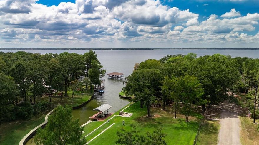 This cedar cabin sits across from waterfront homes on a double lot with fenced back yard. First thing you notice is this charming curb appeal! There is a large open beam covered patio covering this breezy front porch where you can take in the lake views! Step inside to an open, split bedroom design. The island kitchen has 5 burner gas cooktop, all stainless appliances including built in microwave. There are barn doors that open to a vaulted, tongue and groove ceiling master with lots of natural light and views to the lake. The guest bedrooms are off on the other side, one with a direct patio entry of it's own. The baths have heated floors for those crisp, winter mornings, what more can you ask for in this cozy layout? Natural slate floors, dramatic country red cabinets in the kitchen with granite countertop. Lots of room to grow a garden on the second lot, ample privacy and certainly plenty of room to park if you have an RV or a boat. The detached oversized two car garage is a drive through, dual door design. Freshly painted throughout.