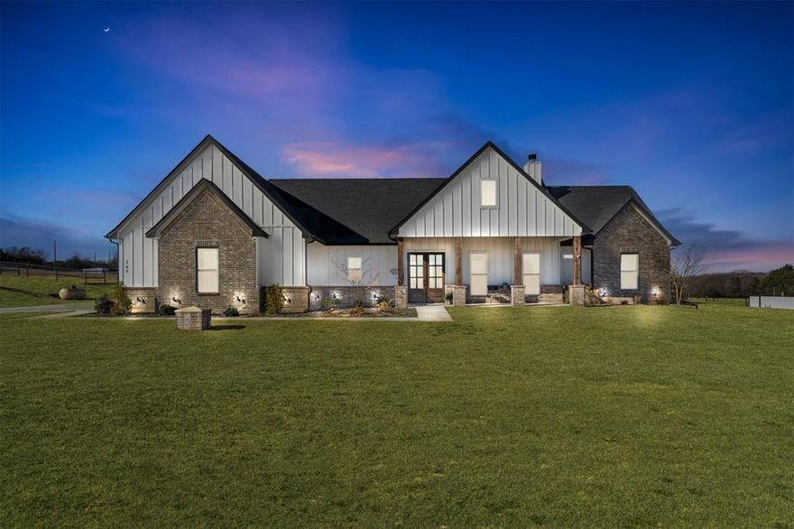 Tucked away on two private acres with no HOA, this stunning custom home offers a rare blend of peaceful country living and modern luxury. A resort-style backyard with a sparkling pool, expansive covered porches, and a fully equipped 30x40 insulated workshop creates a private retreat designed for entertaining, relaxing, and enjoying the quiet space around you. Deed restrictions allows for horses, goats and other livestock.
The 3-bedroom, 2.5-bath home spans 2,230 sq. ft. and includes a flexible home office, with a thoughtfully designed interior featuring vaulted 10-foot ceilings, custom exposed stained wood beams, 8-foot door frames, and large French doors that fill the home with natural light. The main living area is anchored by a striking stone fireplace and flows into the open chef’s kitchen with premium ZLINE appliances, a commercial-grade gas cooktop, multiple ovens, a microwave convection oven, an expansive walk-in pantry, and sleek modern finishes—ideal for both daily living and entertaining.
The private primary suite is a true retreat, offering three spacious walk-in closets with custom built-ins and a spa-inspired bath with soaking tub and rainfall shower. Two additional bedrooms provide comfortable accommodations for family or guests.
Outdoor living is the heart of the home, with multiple covered porches including an extended back patio with stained shiplap ceilings, a stone gas fireplace, stone countertops, and a mini fridge—perfect for morning coffee, gatherings, or evenings by the fire. The backyard features peaceful, tree-lined views, a tranquil pool, and a fire pit for a true resort-style experience.
Additional upgrades include board-and-batten siding, stone archway entry, architectural shingles, spray-foam insulation, tankless water heater, aerobic septic system, well water, and an irrigated sprinkler system covering over an acre. The 30x40 insulated barn and workshop includes finished floors, electricity, water, and a 50-amp RV plug.