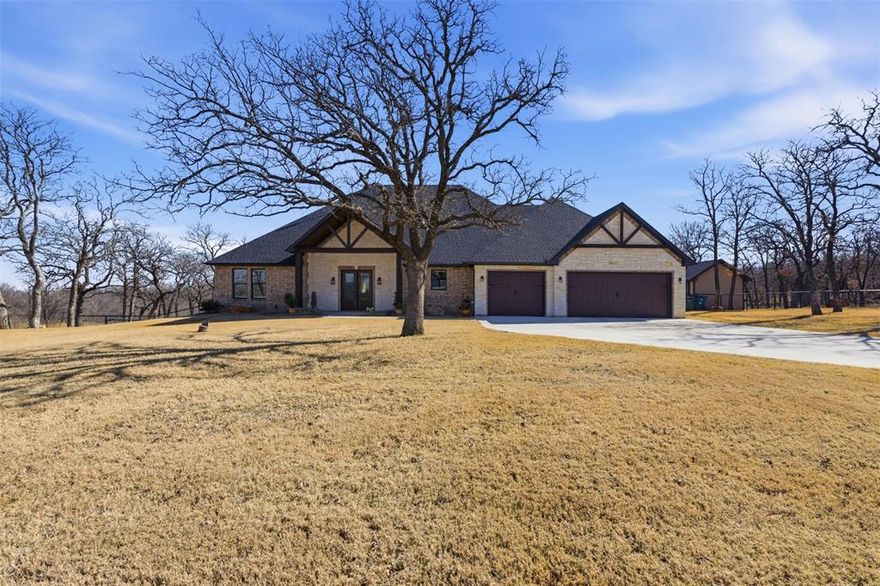 Rustic elegance meets luxury resort style living on 2.54 wooded acres near Lake Bridgeport in the lake community of Runaway Bay. This custom 3 bedroom, 3 bathroom home with an office and a 3 car garage showcases exceptional craftsmanship and thoughtful design throughout. The stunning living room features a dramatic vaulted ceiling with exposed wood beams, rich wood plank detail, plantation shutters, and an impressive stone fireplace that creates a warm yet striking focal point. The open concept layout flows into a beautifully designed kitchen featuring KitchenAid appliances, gas cooktop, farm sink, large island with seating, custom cabinetry, and generous prep space. A bright office overlooks the pool and includes built in desk and cabinetry, creating a functional workspace. The private primary suite offers a spa inspired bath with soaking tub, oversized shower, dual vanities, and a large walk-in closet. Both secondary bathrooms have been upgraded with glass shower enclosures. Additional highlights include a laundry room with two built in pet kennels, sink and room for a refrigerator or freezer, abundant storage throughout the home, and an additional storage room in the garage that could serve as a safe room, gun room, or overflow pantry. The backyard retreat includes a covered patio ideal for entertaining, a heated 16x32 pool with spa, putting green, firepit gathering area, and newly installed turf on the upper portion of the yard. A 12x20 workshop with garage door is located along the side of the home. Residents enjoy access to Runaway Bay amenities including a marina, boat ramp, community dock, fishing, fitness center, clubhouse, community pool, park, playground, and restaurant near beautiful Lake Bridgeport, creating an exceptional setting for lake living, recreation, and outdoor enjoyment throughout the year with stunning sunsets and peaceful surroundings.