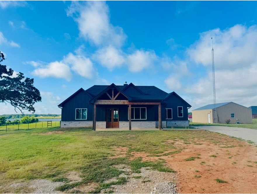 NEW Home with a breathtaking water view of Rhines Lake on 1 acre!  This is a stunning place with lots of big windows to see the lake and features a baking room, craft room, indoor workshop or anything you want it to be.  It has a large covered backporch with amazing views of the lake and the country life. The metal building could be transformed in a beautiful home, man cave or just about anything! This is a must see and would make a great retirement home!