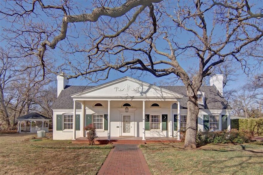 Welcome to 808 Elm Street…a beautiful historic home on the market for the first time in its 90-year history. The house was built by Edgar Ryerson Riggs and his wife Lucie Otey Riggs, who moved to Graham from Georgia. They made their home on 3 lots in the Original Town of Graham. This well-maintained 3,187 sq ft home sits among other grand homes built in the early days of Graham’s history. There are expansive High-ceilinged rooms and original hardwood floors are throughout most of the house. You will feel like you are walking back in time as you enter the front door and step into the grand foyer. Look up and notice the stunning barrel ceiling and original chandelier. Spectacular!  The wallpaper and antique furniture are original to the house. Openings on either side of the entry are a large living room on your right, a smaller sitting room on your left.  Both rooms have large fireplaces with original marble appointments. The picture frame molding detail on the walls adds elegance and style. The windows provide plenty of light and have the original draperies and cornices. The furnishing are mostly antiques that have been in the house from its beginning. Many of the antiques are original to the house may be purchased.  crystal chandeliers and antique lighting fixtures are throughout and help showcase the historic significance of the home. The formal dining room has original wallpaper above the chair rail trim. Two built-in cabinets offer extra display space. A butler’s door opens into a  charming breakfast room with large windows.  There are three spacious bedrooms, one with a Jack and Jill bath which is accessible from the sitting room. The primary bedroom is especially inviting with ambient light from large windows and access to a side porch and the gazebo, with another door accessing the sunroom. There is a large dressing area with access to the primary and a smaller back bedroom. Both bathrooms are charming with original tile, toilets, bathtubs and sinks.