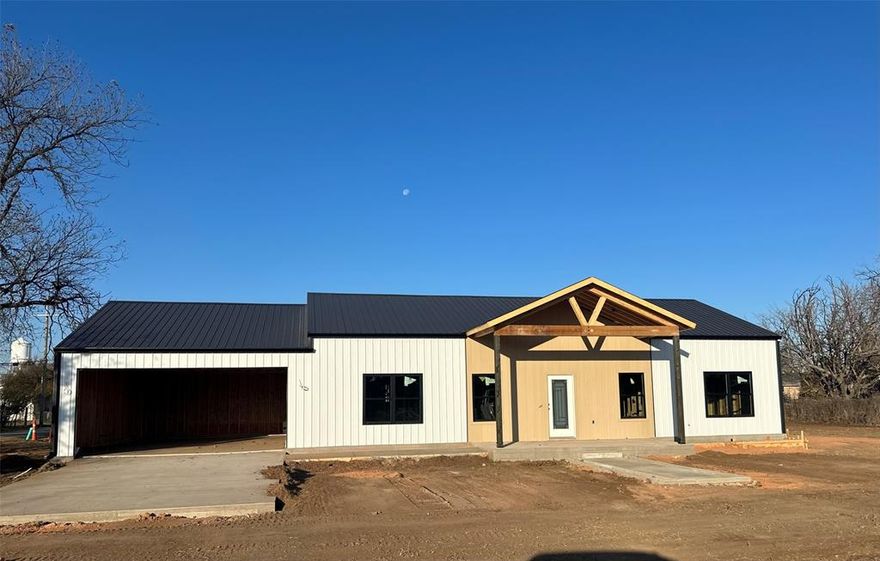 New construction Barndominium by Red Oak Custom Builders going up in Merkel! Wonderful open floorplan with 3 Bedrooms & 2 Bathrooms built on a 9ft plate. Builder's plans for the home - Kitchen to have painted cabinetry, granite on counters, gorgeous walnut butcher block on island, & SS appliances (range, microwave, dishwasher). Spacious utility room. The primary bedroom ensuite has a tub, separate tiled shower, and 2-sink vanity with granite counters. LVP main living areas, carpet in bedrooms. Foam insulation. Class 4 metal roof. Great covered porches, front & back. Metal privacy fence and a garage. Corner lot. Landscaping to include sod in front & back. Wise camera system with 2 cameras & ring doorbell. Builder warranty. This home is just starting so builder's finish out plans ARE SUBJECT TO CHANGE and-or buyer has the opportunity to choose finishes and make some changes at this point, within builder's allowances. The barndos on the corner of S. 6th and Rose St were also built by Red Oak Custom Builders. Photos uploaded with listing are from those homes, just representative of the builder's style. All measurements are approximate.  Lot size is also approximate since it's a larger lot that has been subdivided into two lots. Price change due to change in floorplan, garage enlarged.