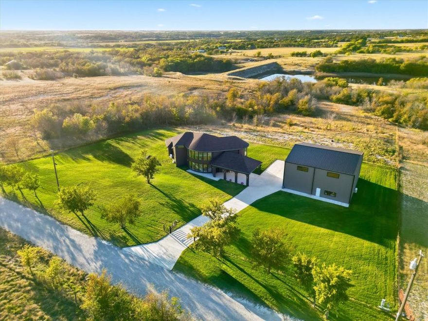 Experience the ultimate in country living in this stuning home completed in August 2024, situated on 5 sprawling acres with breathtaking views of the surrounding countryside. 2 fully fenced and gated acres of lush lawn offer the ideal setting for pets, family, and outdoor entertaining, fully irrigated with high-efficiency Hunter rotors and illuminated with LED landscape lighting for magical evenings under the stars. Step inside to a bright, open floor plan capturing natural light through full-height picture windows, highlighting a seamless blend of modern style and thoughtful craftsmanship. Every detail has been considered, from premium appliances, to dimmable LED lighting and whisper-quiet 22 SEER mini-split heat pumps in every room. The home includes a full mother-in-law suite with its own kitchen, living room, workspace, and separate bedroom, providing private accommodations for guests or extended family. Two tankless water heaters provide unlimited hot water and strong pressure throughout. The open interior flows effortlessly, with neutral tones creating a serene atmosphere, while the covered patio and expansive upper deck allow you to enjoy stunning sunsets and peaceful surroundings. The 5,000 sq. ft., two-story insulated shop offers endless possibilities, including a 30x30 garage, hobby room, mechanical shop, full bath, freight elevator, RV hookups, and a completely open second floor ideal for hobbies, entertainment, or workspace. Remote-controlled solar-powered entry gates, chain-link and wire fencing, flood lighting, and thoughtfully designed outdoor spaces enhance the property. Every element—from ZIP-sealed exterior sheathing, R24 foam insulation, and 2x6 construction to high-efficiency windows and energy-saving systems—ensures comfort, durability, and low utility costs. This home blends modern luxury and peaceful country charm, where every day feels like a retreat surrounded by nature, wildlife, and endless opportunities for work, play, and relaxation.