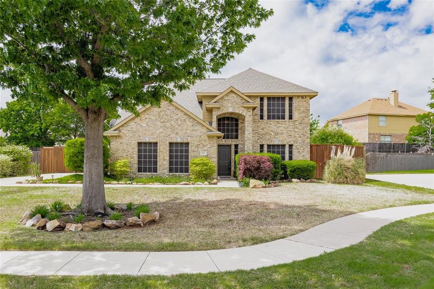 Two-story traditional 3-bedroom, 2.5-bathroom home on a quarter-acre cul-de-sac lot in Quail Hollow Estates, a Sachse, Texas neighborhood known for its larger lot sizes and community pool. This 2,672-square-foot residence offers a flexible floor plan with a first-floor primary suite, a dedicated home office, a second-floor game room, and a separate media room — giving families room to spread out without stepping on each other.
The entry opens to a two-story foyer with hardwood floors and a curved staircase. The kitchen features a center island, a breakfast area, and opens directly to the family room, where a gas-log fireplace with built-in shelving anchors the space. The first-floor primary suite includes a soaking tub, a separate shower, dual vanities, and a walk-in closet. Upstairs, three additional rooms — two bedrooms, a 19x19 game room, and a 12x13 media room — share a full bathroom, giving you real flexibility for guests, hobbies, or a work-from-home setup. Additional features include a half bath on the main floor, an interior laundry room with full-size washer and dryer connections, zoned natural gas heating, and a side-entry two-car garage.
The backyard is built for outdoor living. A covered patio opens to a paver-stone entertaining area with a built-in outdoor grill station, a stacked stone bar, and a separate storage shed — all behind a wood privacy fence. The cul-de-sac location means minimal through traffic and extra curb-side space out front.
Quail Hollow Estates residents enjoy access to the community pool and the kind of spacious lots that are hard to find in newer Sachse, Texas subdivisions. The home sits just off Highway 78, putting you minutes from downtown Sachse shopping and dining, the Firewheel Town Center in Garland, and easy connections to the President George Bush Turnpike. Located in Collin County with Wylie ISD schools.