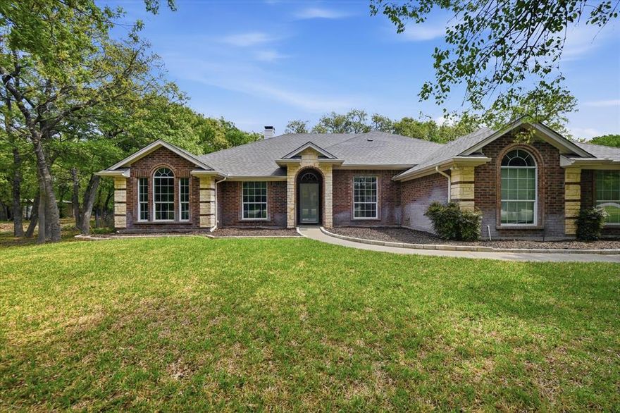 Located in the popular Turtle Creek Ranch community just outside the Fort Worth city limits, this 4-bedroom, 2.5-bath home offers the space, flexibility, and relaxed lifestyle buyers are searching for.  Step inside to a welcoming foyer that opens to a formal dining area and spacious living room with beautiful wood floors, all flowing together in an inviting open floorplan ideal for everyday living and entertaining. The kitchen is designed for gathering, featuring a large island, breakfast bar, abundant counter space, and a refrigerator that stays, making it move-in ready from day one.  The split-bedroom layout offers privacy for the generously sized primary suite, complete with an ensuite bath featuring dual vanities, a soaking tub, separate shower, and a walk-in closet. On the opposite side of the home, three additional bedrooms, each nicely sized that share a full bath, creating a comfortable setup for family or guests. A versatile bonus room provides extra flexibility and is perfect for a game room, office, or entertainment space.  Outside is where this property truly shines. Enjoy relaxing evenings on the covered patio overlooking the fully fenced backyard, all set on a beautiful 1+ acre lot with mature trees that provide shade and privacy. The home also features a 2-car garage and an impressive 16x24 two-story workshop, offering approximately 720 square feet of space with storage below and a finished upstairs game or music room. A constructed aviary adds a unique touch for hobbyists or animal lovers.  With no HOA and a terrific location offering easy access to Fort Worth, Lake Worth, and Azle, this property blends peaceful country living with convenient city access.  Come see the space, versatility, and lifestyle this Turtle Creek Ranch property has to offer.  Schedule your private showing today.