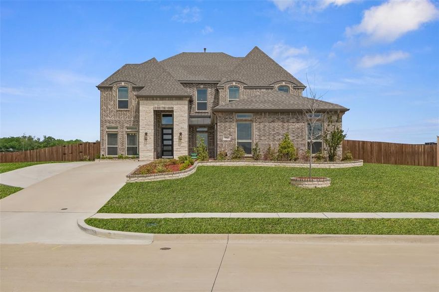 BEAUTIFULLY UPGRADED AT BROADMOOR ESTATES!  This gently lived in 6 bed, 4 bath, 2-story home on the outer perimeter does not currently have a backyard neighbor and is move-in ready with a long list of upgrades.  Built in 2024, this seller chose to enhance the standard plan with an extended driveway and extra fencing along with wider porches on both the front and back exteriors.  Security cameras were added and the media room was equipped with a 110 inch projector that will stay with the home.  Surround sound throughout the entire home is another perk of this stunning home.  A third car garage addition added extra space along with enhanced epoxy garage floors.  Upgraded carpet and engineered hardwood flooring selections were chosen along with quartz kitchen counters and stainless, gas appliances. Rain gutters, sprinkler system and enhanced brick planter beds were also added to the original home. Formal dining space, breakfast nook and additional kitchen island eating offer a variety of dining choices.  Both a butler's pantry and a walk-in pantry serve as a transition between the gorgeous kitchen and the formal dining area.  Trayed ceiling in primary bedroom, vaulted ceilings in family room, and a show-stopping curved, metal staircase all contribute heavily to the constant wow factors you will encounter.  Multiple walk-in closets, great storage, and a separate office area with double glass doors make this the perfect home for a growing family.  Red Oak ISD. Broadmoor Est has a mandatory HOA managed by Singer Mgmt and is $1,100 per yr. Assumable VA loan per seller!