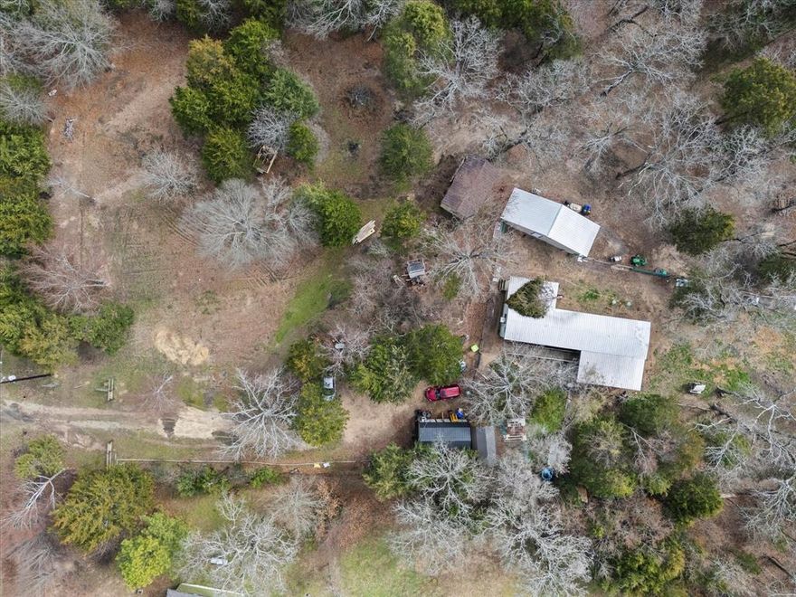 Great opportunity to escape the chaos of city living, with easy access to city amenities. Great opportunity to live in the mobile home while building your custom home. Just under 5 acres of serene, partially cleared land ready to be built on. Currently there are several outbuildings, Mobile Home, storage buildings, fences, gardens and more! Everything can stay or go depending on the buyers desires or needs.  Call now to get more information.