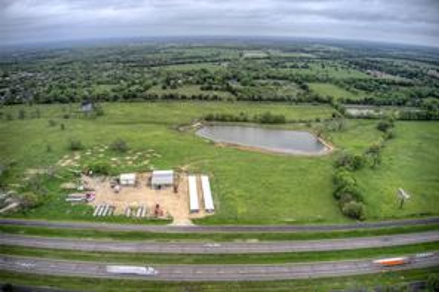 INCOME-PRODUCING!! Mini Storage units less than a year old, and 2 other 2 buildings currently occupied and leased. one is finished out with offices and roll-up doors, another building is a shop with concrete floors! The property also has a billboard lease on it as well. All the possibilities with ALL THAT ACREAGE ON THE INTERSTATE! The front has Interstate 30 Frontage, the side has frontage road access and the rear has railroad! Part in the City Limits, and part in the county! This property has a good mix of both pasture and trees. 2 Very large fishing ponds and easy to get to.  It can be your home, or business, or BOTH. Owner Financing could be a possibility with the substantial down payment.