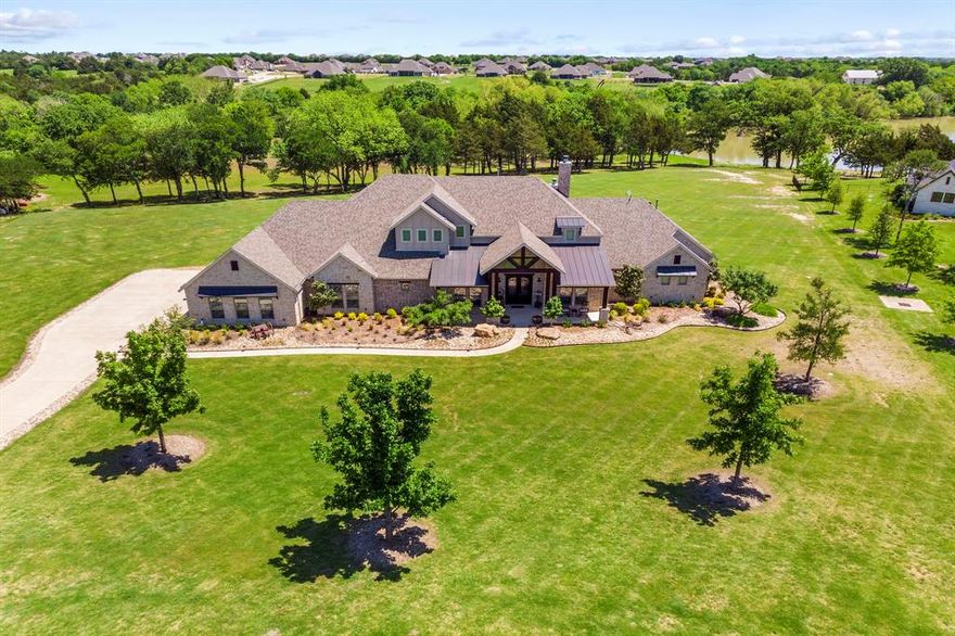 A rare opportunity to own a beautiful 5140 sqft home on 5 acres that backs up to the main 27 acre pond in the gated community of Waterstone Estates. 1.5 story (1 bdrm suite with full bth, media, & a 2nd half bath up) 5 total bdrms, 5 full & 2 half baths, Study, gm rm, media with kitchenette, wine room, wet bar & 4 car gar. Enter through the custom iron doors into an elegant foyer with extensive use of White Oak wide plank wood floors. Wall of windows from liv rm & bfast nook overlooks the sparkling diving pool, covered patios, built in kit & fireplace, & tranquil views of the woods & water. Chefs kitchen boasts double stainless convection ovens, 6 burner gas cktp, quartz ctops, pot filler with tons of cabs and ctops. Large liv rm with massive cedar beams & Austin Stone FP. Whole Home audio by Sonos. Spray foam insulation, low E windows, & radiant barrier for max efficiency. No city taxes, tax rate is only 1.71. Exemplary rated Melissa ISD. Come see today!