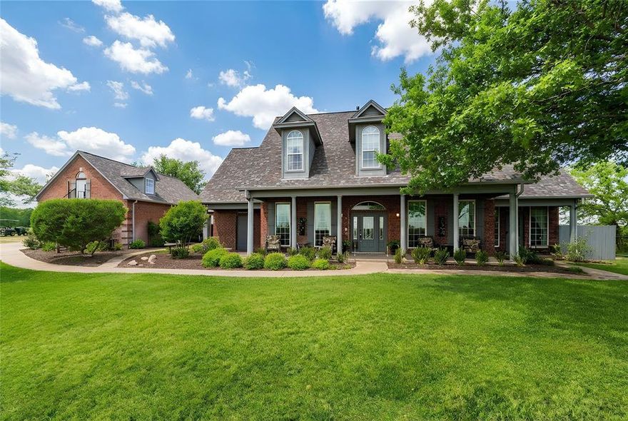 Perched atop its own private hill, this stunning West Hill Estates property offers nearly 7 acres of premier horse-ready living in highly sought-after Aledo ISD. Behind an electric gate, a private drive leads you to a breathtaking hilltop home with panoramic views that set the tone for this exceptional estate. Designed for both luxury and function, the pipe-fenced property is fully equipped for equestrian enthusiasts, featuring an arena, corral, stables, and tack room—bring your horses and ride from home. The residence spans over 4,000 square feet and welcomes you with a large covered front porch, perfect for morning coffee or taking in the serene views. Inside, soaring ceilings create a grand and inviting atmosphere. The spacious dining room flows seamlessly into the family room with a gas fireplace, ideal for entertaining. The chef’s kitchen is a true showpiece, complete with a 5-burner gas cooktop, double ovens, abundant cabinetry, walk-in pantry, oversized granite island, custom Italian Venecia sink, and a bright breakfast room overlooking the pool. The first-level primary suite is generously sized and offers a spa-like ensuite bath with heated flooring, an expansive walk-in shower, and dual granite vanities. Upstairs, you’ll find three additional bedrooms, two with ensuite baths, plus a versatile bonus room. An attached three-car garage provides ample parking, complemented by an expansive driveway. Above the garage, a private guest apartment offers its own kitchen, bedroom, bathroom, and yoga room, with cleverly tucked-away closets for optimal space. Outdoor living is truly remarkable, featuring sweeping views, a sparkling pool and spa, and the freedom to enjoy your horses on your own land. A John Deere tractor with front-end loader, box blade, seed spreader, and brush hog, along with a generator, will convey. There is also a storm shelter.  This is a rare opportunity to own a luxurious hilltop equestrian estate in Aledo ISD.