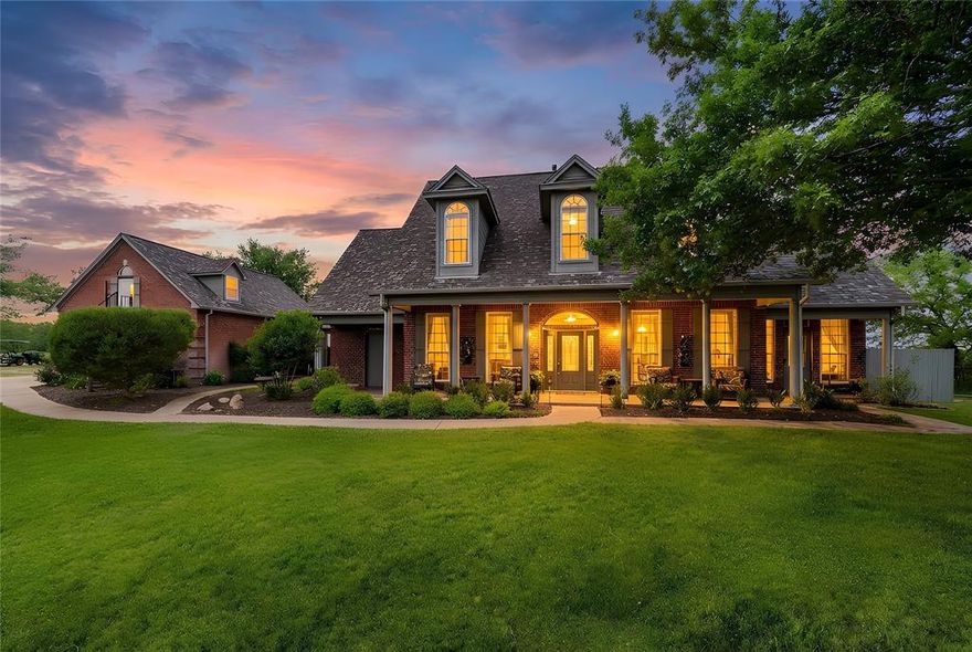 Perched atop its own private hill, this stunning West Hill Estates property offers nearly 7 acres of premier horse-ready living in highly sought-after Aledo ISD. Behind an electric gate, a private drive leads you to a breathtaking hilltop home with panoramic views that set the tone for this exceptional estate. Designed for both luxury and function, the pipe-fenced property is fully equipped for equestrian enthusiasts, featuring an arena, corral, stables, and tack room—bring your horses and ride from home. The residence spans over 4,000 square feet and welcomes you with a large covered front porch, perfect for morning coffee or taking in the serene views. Inside, soaring ceilings create a grand yet inviting atmosphere. The spacious dining room flows seamlessly into the family room with a gas fireplace, ideal for entertaining. The chef’s kitchen is a true showpiece, complete with a 5-burner gas cooktop, double ovens, abundant cabinetry, walk-in pantry, oversized granite island, custom Italian Venecia sink, and a bright breakfast room overlooking the pool. The first-level primary suite is generously sized and offers a spa-like ensuite bath with heated floors, an expansive walk-in shower, and dual granite vanities. Upstairs, you’ll find three additional bedrooms, two with ensuite baths, plus a versatile bonus room. An attached three-car garage provides ample parking, complemented by an expansive driveway. Above the garage, a private guest apartment offers its own kitchen, bedroom, bathroom, and yoga room, with cleverly tucked-away closets for optimal space. Outdoor living is truly remarkable, featuring sweeping views, a sparkling pool and spa, and the freedom to enjoy your horses on your own land. A John Deere tractor with front-end loader, box blade, seed spreader, and brush hog, along with a generator, will convey. There is also a storm shelter.  This is a rare opportunity to own a luxurious hilltop equestrian estate in Aledo ISD.