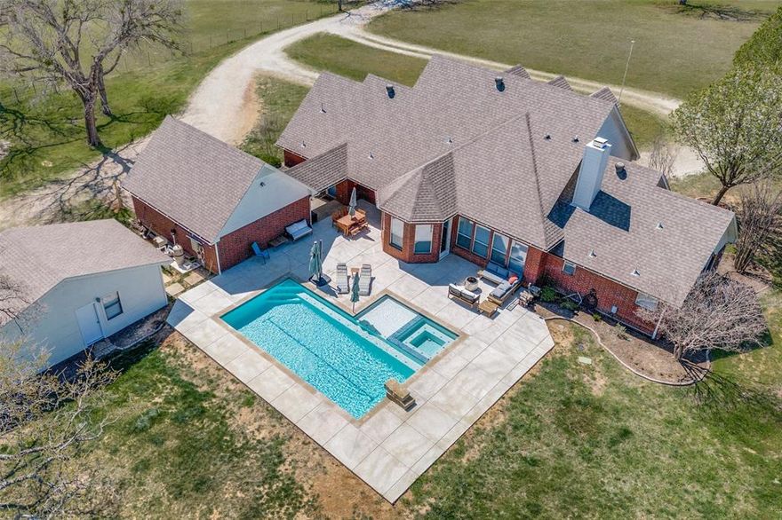 Stunning, tranquil 16.5 acre property with updated residence, guest house, pool + spa and tons of fairytale mature trees. **AG EXEMPTION IN PLACE** - take advantage of hugely reduced property taxes. Bring your cattle or horses here to graze - fully fenced property with a spring fed creek. Perhaps you are looking for the perfect weekend get-away to escape the City, or a peaceful hobby farm - look no further! Prime opportunity to develop the land with potential for approx. 10 x 1 acre lots plus the primary residence. Development happening all around! Situated less than 1 min off Hwy 380 & across the road from Lake Lewisville. Beautifully updated home w fresh paint throughout & recently remodeled primary bathroom of your dreams! 3,194 sq feet & all the rooms your family could desire with 5 beds, 3 baths, game room and flex space that could be office, study or dining room.  Kitchen is open to large living room with stunning views of the pool and pastures beyond. Great layout! Downstairs has private primary suite on one side and 2 guest beds + full bath on the other. Primary has room for sitting area or your Peleton. Primary bath remodeled with  stand alone tub, tile and frameless glass shower, quartz countertops, huge walk-in closet. Upstairs has 2 beds, game room & a full bath. Views of trees and animals from every window. Living room flooded with natural light and focused around a gorgeous stone fireplace. Denton less than 10 min west and Frisco 15 min east. Resort style pool added in 2024! Live your best life sipping your favorite drink in the attached spa and enjoy the greenery and open space surrounding you! Land features premium sandy loam soils, fenced pastures, & a great mix of bermuda grass pastures in the front w a densely wooded back pasture. The Detached wood frame house adds 461 more sq ft w bathroom and kitchenette. Sale includes 2 lots combined to make 16.5acres. Surveys are available. Property incl. large chicken coop + storage shed w ramp & garage door.