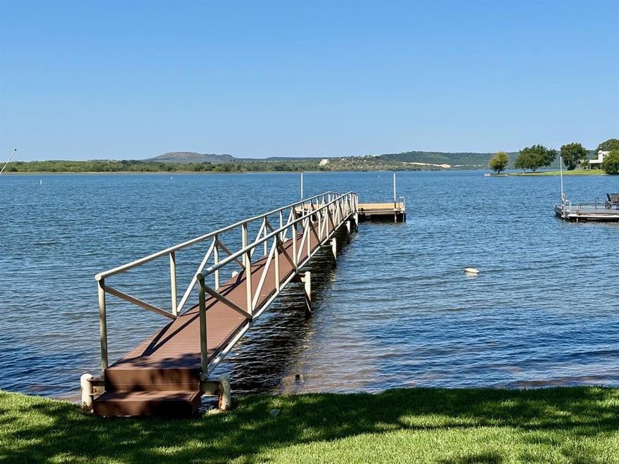 Nestled on the shoreline of scenic Possum Kingdom Lake sits your waterfront oasis. Build your dream home on this level, easy to care for lot with lush grass and a swim dock already in place, or renovate the older, nostalgic home. There's a reason you hardly ever see homes on this street come up for sale, because it's the perfect, quiet neighborhood that you'll want to keep as long as possible. Perfect location on the Peninsula, just a minute to shopping and eateries with live entertainment,  there's always something to do and a perfect sunset to be seen. Looking out at the crystal blue waters of the Great Lake of Texas, you'll never tire of the peaceful feeling this lake gives you. Enjoy cooking out after a long day of playing on the water, you've never had relaxation like this. Bring your builder of choice and make your dreams become a reality, opportunities like this don't present themselves often, so don't wait! Priced to sell!