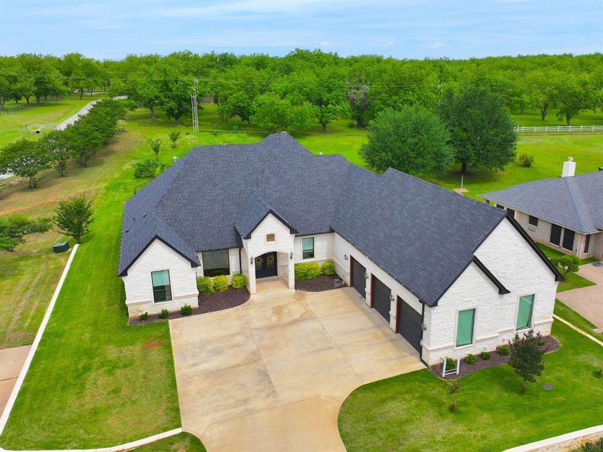 Luxury living at its finest in the gated community of Pecan Plantation with unlimited golf. This stunning custom home sits on a half acre lot and offers a refined blend of elegance, comfort, & thoughtful design. With 4 spacious bedrooms, 4 full bathrooms, a media room, private office, plus an open floor plan, every detail has been carefully considered. The light-filled living area features large windows with electric shades and a gas fireplace, creates a warm, inviting atmosphere. The chef’s kitchen is designed for both beauty & function, showcasing a commercial-grade gas range, oversized breakfast bar, abundant cabinetry, & an oversized walk-in butler's pantry with sink, ice maker, & tons of cabinets, ideal for entertaining & everyday living.

The primary suite is an exceptional retreat, complete with its own gas fireplace, expansive windows with electric shades, spa-inspired ensuite featuring separate vanities, a soaking tub, walk-in shower, and an impressive custom closet with a dedicated dressing and makeup area plus a private closet for weapon storage. The utility room connects directly to the primary closet and includes built-in cabinetry, tons of counter space, and room for a secondary refrigerator or freezer. 

Upstairs offers a media room with a full bathroom, perfect for guests or movie nights. A dedicated office with French doors & dual built-in desks provides an ideal work-from-home space. Outdoor living is just as impressive with a fully fenced backyard, covered entertaining area with built-in Green Egg, gas grill, refrigerator, generous seating, and a wood-burning fireplace with room for a mounted TV.

Additional features include an oversized, deep three-car garage and custom finishes throughout, and whole-home generator. Pecan Plantation residents enjoy gated security, golf, marina access, clubhouse amenities, lake privileges, and a luxury lifestyle unmatched in Granbury including its own grocery store, pharmacy, bank, hardware store & more.
