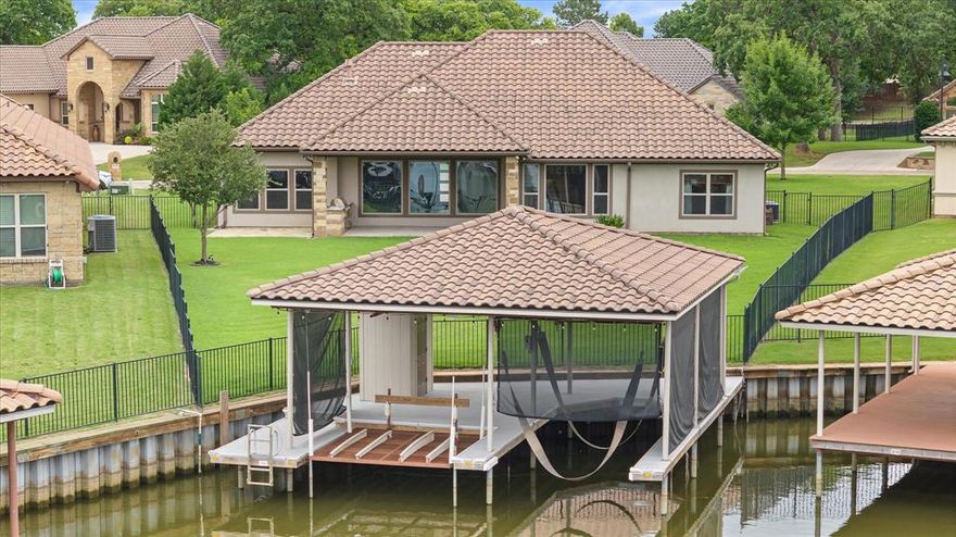 Ready for Lake Granbury living, this is your chance,  this beautiful Rock Ridge Homes built 3 bedroom, 2.5 bath open concept home is on the canals of much sought after Catalina Bay development.  Just minutes from shopping, dining, and entertainment of Historic Granbury and just a golf cart ride from Harbor Lakes Golf and club which provides golf and social memberships.  Home is move in ready, and you could be celebrating and enjoying the summer on Lake Granbury.   Home has a split bedroom setup with primary and ensuite bath, with 2 additional bedrooms separated  by a Jack and Jill bath setup.  Home is located in a gated community, and has a dock on canal that goes to mainbody,  boat dock has a boat lift for a boat, as well as jet ski dock, on dock storage and ladder for cooling off in the lake and enjoying those hot summer days.  The home has an office inside the front door, then opens up into living, dining and kitchen area which is open concept and has a gas fireplace, with huge glass windows facing the lake, and electric window covers to shade the sun.   Home has hardwood floors, with ceramic tile and carpet in bedrooms.  Kitchen is a chefs love with high end appliances, and just off dining room is covered patio, with a outdoor cooking area and gas grill.  This area of Granbury is golf cart friendly to ride your cart to stores and eating establishments.   You will love the gated community of Catalina Bay, and the hometown feel of Granbury and its historic festival filled City.   This home would make a great new home or your vacation get away to leave the big city behind.   Come see what many know and love about Lake Granbury.