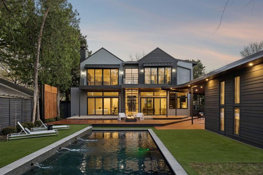 Some homes are designed to impress. This one was designed to live beautifully. Set on a private .43 acre lot in Preston Hollow and surrounded by mature trees, the home unfolds through clean modern lines, warm natural materials, and walls of glass that pull the outdoors into every room. The main living spaces open effortlessly to the backyard, where a resort style pool, outdoor kitchen, and full cabana create a setting that feels both relaxed and refined. At the center of the home, the kitchen anchors daily life and entertaining with an oversized island and professional grade appliances, while a wet bar and wine storage add another layer of thoughtful detail. Upstairs, the primary suite is intentionally positioned as a true retreat, removed from the activity of the main level and offering its own sense of privacy with a balcony overlooking the grounds and a spa inspired bath. Additional bedrooms and living areas provide flexibility without sacrificing flow, while the architecture keeps every space feeling connected to light and landscape. Moments from Dallas’ most sought after private schools, this is a home that balances design, comfort, and quiet presence in one of the city’s most established neighborhoods.