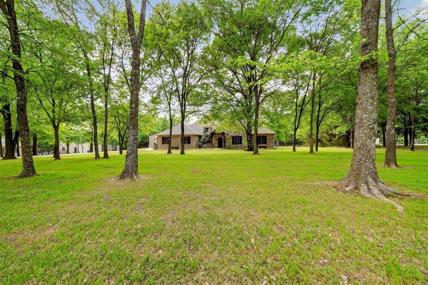 Luxury Country Living! Welcome to 2211 Canyon Lake Road. Single-story home on 5+ wooded acres in the desirable Shadow Lakes community of Wills Point, TX! This 3-bedroom, 2.5-bath home with a dedicated office offers an open-concept layout designed for both comfort and entertaining. Interior features include custom-built cabinetry, granite countertops, ceramic tile throughout, all LED can lighting, and a new dishwasher. Energy-efficient upgrades include radiant barrier attic decking and SunTex solar screens. Step outside to your private retreat featuring a stunning saltwater heated pool, (installed Summer 2024) complete with spa, waterfall, tanning ledge, bubblers, and LED lighting, all app-controlled. The outdoor living space also includes a fully equipped kitchen with grill, refrigerator, and storage, plus a second patio with a large second stone fireplace-perfect for gatherings year round. The property includes a 30x60 shop with two 12x10 roll up doors and a bathroom, an oversized garage, and a wrought iron fenced backyard with double gate access. Enjoy a scenic setting with mature trees, beautiful landscaping, a small pond, and plenty of space to roam. Additional features include 4K security cameras and custom Christmas lighting, that stays with the home. Located in a community offering multiple lakes, fishing, hiking trails, and a pool, with convenient access to Hwy 20 and nearby amenities. Turn-key and move-in ready! This property truly has it all!
