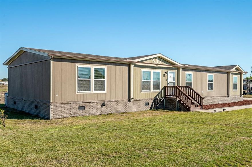 This beautifully upgraded manufactured home sits on a FULL ACRE in a peaceful neighborhood with NO HOA, offering space, privacy, and freedom. Inside, the open-concept layout features a spacious living room filled with natural light, complete with built-in shelving around the TV area, seamlessly connected to the kitchen and dining space. The kitchen is a true centerpiece, showcasing a massive island with seating, sleek stainless steel appliances, a decorative tile backsplash, and rich cabinetry that blends style with function. The primary suite provides a relaxing retreat with a soaking tub, separate shower, dual vanities, and a generous walk-in closet. Three additional bedrooms and a built-in study nook offer flexibility for family, guests, or remote work. Oversized utility-mud room with cabinetry. Energy efficiency shines with 38 paid-in-full solar panels—monthly AC costs average under $50, and heating stays below $100. Outside, a metal outbuilding garage accommodates up to four vehicles and includes six outlets on separate breakers, ideal for workshop use. Enjoy the outdoors with a spacious deck perfect for unwinding, four rainwater catchers, lush Zoysia grass, and a sprinkler system around the home. Horses allowed. Located just minutes from Princeton and Lucas, this property combines rural tranquility with convenient access to town.