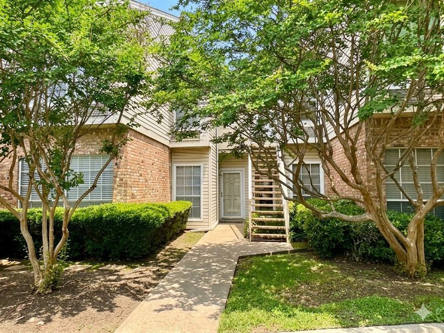 Modern 1st-floor living meets prime North Dallas location. This 882 sq. ft. updated condo is zoned for Brentfield Elementary in Richardson ISD and offers a seamless blend of style and function. The open-concept interior is anchored by a spacious living area featuring a wood-burning fireplace with a walnut mantel, a custom wet bar, and large windows that draw in natural light.

The updated kitchen is a standout, equipped with stainless steel appliances and a dual-zone wine fridge, perfect for entertaining. Step through french doors to a private patio overlooking a serene green space and flowing creek. Both bedrooms offer a quiet retreat, while the modern bathroom features a tiled tub enclosure.

Key Features & Location: HVAC installed March 2022; contemporary lighting throughout. Assigned covered parking and community pool with stone decking and grilling station. Minutes to UT Southwestern, Baylor Scott & White, and both convenient access to DFW and Love Field Airports. Near DART Rail Addison Station for easy commutes to Downtown Dallas.

Experience low-maintenance living with rapid access to the best of North Dallas and Richardson.