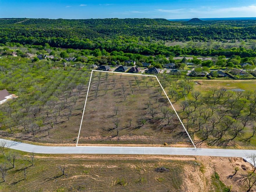 Howdy! Welcome to The Ranches neighborhood of Pecan Plantation Phase 1. LOT 3687, 3113 E Landings S, 4.115 acres. Lot dim 364 x 608 x 278 x 520. Site is complete with paved roads, underground electric service, AMUD water, septic required, Orchard irrigation & fiber optic high speed internet available. Choose any builder you would like and no time frame to build. Min SQ FT 2,200. This LOT is one of the highest elevated lots in the Ranches with TOP TIER VIEWS of hills to the South and has Equestrian trail access all along the South and West property lines. Bring your HORSES, they will love the sandy loam soil. Discover the exceptional lifestyle of Pecan Plantation, a private, gated community nestled along 17 miles of the historic Brazos River within a 4,200 acre pecan orchard. Enjoy resort style amenities including two championship golf courses with full practice facilities, an additional golf course under construction, a full-service clubhouse with multiple dining options, marina with access to Lake Granbury, tennis & pickleball courts, pools, dog park, riverside parks, Airparks, camping, & 24 7 security with Fire & EMS services. The Village, features a bank, grocery store, restaurant, Pecan Medical Clinic, PT Services, pharmacy, golf cart shop, Vet Clinic, car wash, & Ace Hardware. Just minutes from the Historic Granbury Square officially the “Celebration Capital of Texas” under an hour from Fort Worth. Experience the perfect blend of tranquility, recreation, and convenience. Come see why you’ll want to build your dream home here! PPOA Mandatory Membership as of 9-1-25: PPOA Transfer Fee 1,091.00 + 73.65 (tax) = 1,304.49. Initiation Fee 4,381 EQUALS: 5,545.65 The monthly fee is 204.75 and includes trash service or 182.75 without trash service. Search YouTube 'Airplane Ride Around Pecan Plantation Rebecca Van Buren' to learn about our amazing community.