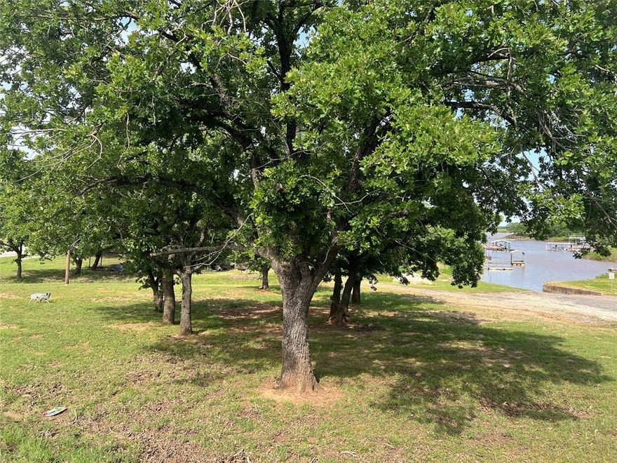 Rest & relaxation is waiting on this petite size lot with part of adjoining lot to be included under pretty shade trees. Perfect gathering space for cookouts & a day on the lake. Bring your gear & enjoy lots of good fishing & lake activities on this already cleared lot. Easy in & out with your boat as boat dock is almost adjoining around the corner. Property has electric on site. Great place to get out of the sun after a day on the lake under the tree coverage. Build your small get away home with only a 600 sq ft minimum requirements to meet the deed restrictions. Mobile homes are permitted. Groomed & ready for a new owner. One of the few lots for sale with a main body Lake Nocona view & some waterfrontage. A survey will need to be completed to determine lot size. Septic system installation would need to be verified with a septic system professional. Please contact listing agent regarding lot information & not the HOA. This lot is owed by an individual & is not the property of the HOA.