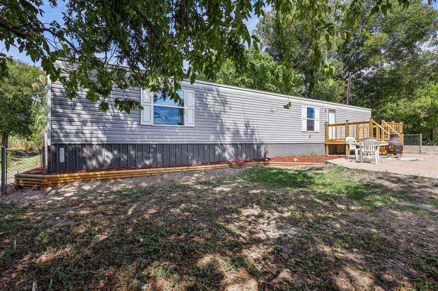 Welcome home to this like brand new 2022 Clayton 14WX60L, 2 bedroom, 2 bath, 840 square feet single wide manufactured home located in the gated Lake Granbury community of Indian Harbor! This home and property shows pride of ownership throughout. Newer HVAC recently installed! Inside you will find wood look laminate flooring throughout, large open living room, open kitchen complete with black appliances. Refrigerator, stove, dishwasher. Separate utility room just off the kitchen with full washer and dryer connections. Breakfast area just off the kitchen with window views. Roomy master bedroom with ensuite bath and walk in closet. 2nd bedroom located at opposite end of the house for the ultimate in privacy. 2nd bedroom features a walk in closet and its own private bathroom. Exterior of home features a seasonal creek in the back of the property and an extra large front deck with plenty of room for grilling, sitting, and relaxing! Vinyl siding and a shingle roof. Large front patio area with views and privacy. Chain link fence and wood privacy fencing will give you a secure and private yard. Indian Harbor is a beautiful gated and guarded Lake Granbury community that features 24 hour security. Enjoy Lake Granbury access from a community boat ramp, community marina, community marina restaurant, community pool, walking trails, clubhouse, community library, and a community fire department. You get all these amenities with a very low cost HOA. Community is centrally located just minutes from Glen Rose and minutes from the Historic Granbury Square. Coop Electric, high speed internet, cable TV, and more all available. This cozy and cute mobile home is priced to sell and makes a perfect home for a first time homebuyer, investor, or someone looking to downsize.