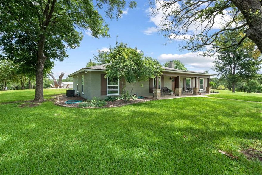 Gorgeous Remodeled Country Retreat on 26 Acres with access to 2 large bodies of water, 1 being a conservation lake and the other a large pond, both stocked with fish. Welcome to your private paradise in the sought-after Lago Linda community of Peaster. This beautifully remodeled 3-bedroom, 3-bath home with a large bonus room offers 2,853 sq ft of stylish living space. Step inside to discover thoughtful upgrades throughout — LVP floors, new carpet, an updated kitchen with white cabinets and gorgeous granite, a huge walk-in pantry, a formal dining room with built-ins, a gorgeous living room with a fireplace and built-ins, new windows, and doors. The spacious living areas feature a LOPI fireplace insert & a wood-burning stove. The home’s efficiency and care are second to none: additional blown-in insulation for year-round comfort. 3-year-old Class 4 roof, both AC heat-pump units are newer, 2-ton brand-new; 3-ton, 6 years old. Enjoy a sparkling pool with a heat pump that extends the swim season by several months. The front pond and stocked lake are teeming with bluegill, bass, crappie, and catfish — it’s not uncommon to land a 5-lb bass! This property truly shines with a 30x50 shop with electricity, a roll-up door, and a walk-through door, plus an additional 20x30 attached breezeway for equipment, and an attached 11x19 and 10x11 storage. 2 high-yield wells easily supply the home, shop, and 10-zone sprinkler system without ever needing recharge. Wildlife lovers will appreciate the abundance of turkeys, deer, and Canada geese. The sandy-loam soil is ideal for horses or cattle; the west pasture is already fenced on two sides. With a bit more fencing, you’ve got a turnkey setup. The shop and wells sit on their own electric meter with room for expansion. Whether you’re fishing at sunrise, swimming under the Texas stars, or sipping coffee while watching the wildlife wander by, this remarkable property offers an unmatched lifestyle of peace, space, and natural beauty.