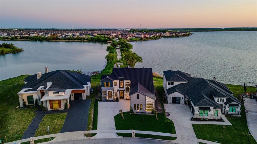 Luxury Lakefront New-Construction Home, Private Peninsula on Lake Ray Hubbard, Rockwall–Heath 
Experience luxury waterfront living in this brand-new modern custom home located on a private peninsula on Lake Ray Hubbard, offering unparalleled shoreline views and potential space for your future private boathouse. This rare opportunity combines architectural sophistication, premier craftsmanship, and breathtaking true lakefront access in the highly desirable Rockwall–Heath luxury corridor.
Designed by elite custom home builders in Rockwall, this residence features exquisite curated finishes including Ivory Macabus quartzite countertops, authentic European oak wood floors, large-format slate tile, designer lighting, and soaring 12-foot ceilings throughout.
The expansive open-concept living, dining, and kitchen area showcases dramatic 12-foot sliding iron doors and floor-to-ceiling windows, framing unobstructed panoramic water views — the perfect backdrop for luxury lakefront living and entertaining.
Primary Suite with Waterfront Views
Wake up to peaceful lake scenery from the luxurious primary suite complete with:
Cathedral ceiling and panoramic lakefront windows
Spa-inspired ensuite with walk-in dual rain shower
Freestanding soaking tub
Quartz countertops, dual vanities
Custom designer closet system
Spacious second-Level Entertainment Loft functions as a media room + game room combo, featuring glass sliding doors opening to a private balcony — the ultimate spot to enjoy sunset views and watch evening sailing regattas glide across Lake Ray Hubbard.
Direct Lake Ray Hubbard waterfront — true lakefront
Private peninsula lot with shoreline for future boathouse
Luxury new construction modern architectural design
Premium bespoke materials and designer finishes
12’ ceilings & floor-to-ceiling iron + glass
Spa-quality primary retreat with lake views
Entertainment loft + balcony overlooking the water
Rockwall–Heath luxury home market location