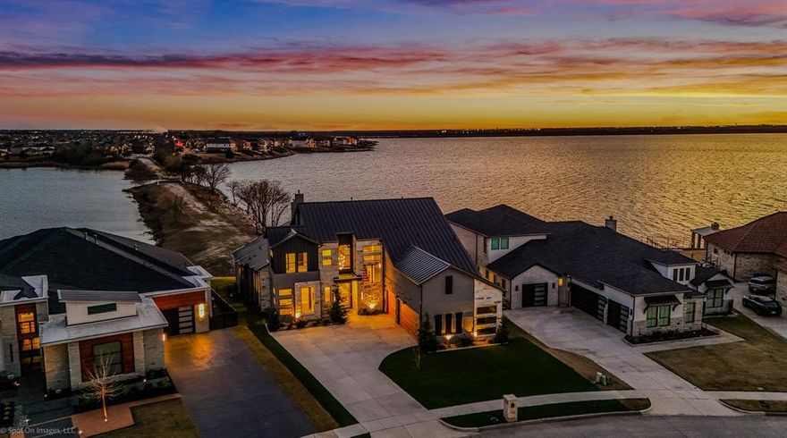 Luxury Lakefront New-Construction Home, Private Peninsula on Lake Ray Hubbard, Rockwall–Heath 
Experience luxury waterfront living in this brand-new modern custom home located on a private peninsula on Lake Ray Hubbard, offering unparalleled shoreline views and potential space for your future private boathouse. This rare opportunity combines architectural sophistication, premier craftsmanship, and breathtaking true lakefront access in the highly desirable Rockwall–Heath luxury corridor.
Designed by elite custom home builders in Rockwall, this residence features exquisite curated finishes including Ivory Macabus quartzite countertops, authentic European oak wood floors, large-format slate tile, designer lighting, and soaring 12-foot ceilings throughout.
The expansive open-concept living, dining, and kitchen area showcases dramatic 12-foot sliding iron doors and floor-to-ceiling windows, framing unobstructed panoramic water views — the perfect backdrop for luxury lakefront living and entertaining.
Primary Suite with Waterfront Views
Wake up to peaceful lake scenery from the luxurious primary suite complete with:
Cathedral ceiling and panoramic lakefront windows
Spa-inspired ensuite with walk-in dual rain shower
Freestanding soaking tub
Quartz countertops, dual vanities
Custom designer closet system
Spacious second-Level Entertainment Loft functions as a media room + game room combo, featuring glass sliding doors opening to a private balcony — the ultimate spot to enjoy sunset views and watch evening sailing regattas glide across Lake Ray Hubbard.
Direct Lake Ray Hubbard waterfront — true lakefront
Private peninsula lot with shoreline for future boathouse
Luxury new construction modern architectural design
Premium bespoke materials and designer finishes
12’ ceilings & floor-to-ceiling iron + glass
Spa-quality primary retreat with lake views
Entertainment loft + balcony overlooking the water
Rockwall–Heath luxury home market location