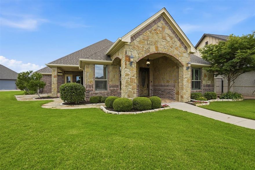 Welcome to the charming enclave of Fountain Village—a coveted gated community known for its uniquely styled custom homes, beautifully maintained grounds, and true lock-and-leave convenience. This pristine, move-in ready home offers the perfect blend of luxury, comfort, and maintenance-free living.

With a light & lovely color palette, the home showcases wide-plank engineered wood flooring in warm earth tones, plantation shutters throughout, beautiful designer surfaces, and abundant natural light creating an inviting atmosphere from the moment you enter.

The spacious open-concept is designed for effortless living & entertaining. At the heart of the home is an oversized galley kitchen that is open and connected—flowing seamlessly to the island, dining area, and expansive great room beneath a vaulted ceiling. The kitchen offers lovely granite countertops, generous bar seating, exceptional workspace, and storage galore rarely found in traditional galley-style designs. A beautiful stone fireplace anchors the living space with warmth and character.

A split-bedroom floor plan provides privacy for owners and guests. The primary suite is filled with natural light and features generous countertop space, an oversized walk-in shower, abundant closet space, and a beautifully appointed spa bath designed for comfort and functionality.

The oversized utility room offers abundant cabinetry, expansive countertop workspace, a large sink, and additional storage. Spacious courtyard and patio areas create a peaceful private retreat for relaxing or entertaining.

Ideally situated on Centre Court, this home enjoys Fountain Village amenities including fountains, gazebos, landscaped common areas, a clubhouse, and pool. Low monthly HOA dues include front yard maintenance.

Conveniently located on the Fort Worth side of Granbury, you are minutes from shopping, dining, entertainment, medical services, the Historic Granbury Square, and quick access to Fort Worth and DFW Airport.