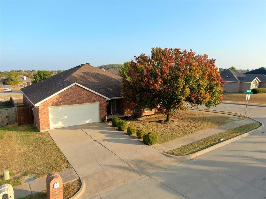 Well-maintained brick 3-bedroom, 2-bathroom home with 2-car garage built in 2002 in Burleson, Texas! This 2,354 square foot home is located on a corner lot and features an open concept layout with tile floors and luxury vinyl plank flooring throughout. Large windows provide plenty of natural light. The kitchen has a pass-through open to the living room, creating an ideal space for entertaining and family gatherings. The living room showcases a double-sided wood burning fireplace, adding warmth and ambiance to the home. An extra sitting room with large windows offers additional living space. The large primary bedroom includes a sitting area for relaxation. The ensuite primary bath features dual sinks, a separate shower, a garden tub, and his and hers walk-in closets for ample storage. The additional bedrooms include ceiling fans and share a full bathroom with a shower tub combo. A separate laundry room provides convenient functionality. Central air and heat keep the home comfortable year-round, and the roof was replaced approximately 5 years ago. The large fenced backyard includes a separate fenced area perfect for dogs, offering both space and security for pets!