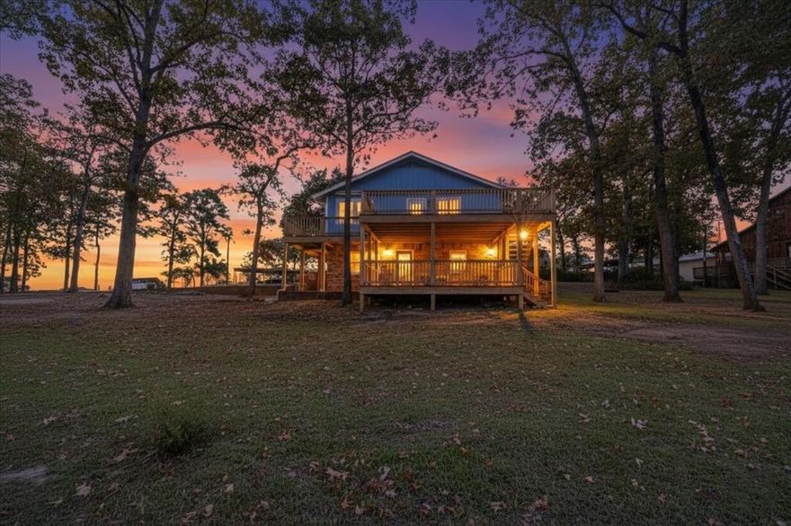 Panoramic Lake Palestine views greet you from nearly every window in this beautifully renovated waterfront retreat. Offering approximately 250 feet of shoreline across three lots on deep water, tucked away on a quiet cul-de-sac and peninsula for ultimate privacy and presence. With additional lease-back area, the total footprint may span approximately 0.80 acres. Located in a neighborhood that allows short-term rentals, this home presents exceptional flexibility whether as a full-time residence, weekend escape, or income-producing investment.

The main level offers an inviting living space with custom built-ins and a fireplace, flowing seamlessly into a spacious dining area, and kitchen with granite countertops, stainless steel appliances, with reverse osmosis and room for a deep freezer.  Down the hall you'll find a full bathroom with a large walk-in shower and two spacious bedrooms with lake views. 

Downstairs, the lower level is ideal for multi-generational living or rental flexibility. A private primary suite captures stunning lake views and includes an en suite full bathroom. An additional living area with a cozy wood-burning stove, and lake views as well, with a generous sized fourth flex bedroom with a walk-in closet.  Plus a spacious utility room or a future 2nd kitchen could immediately turn this home into a multifamily unit or investment opportunity.

Outdoor living is just as impressive, with updated wraparound decks on both levels, all positioned to maximize sunset views and lakeside entertaining with privacy. The boathouse features two slips with motorized lifts, making lake days seamless and year-round enjoyment effortless.

The versatile layout and generous parking and multiple entrances on both levels make hosting effortless and stairs not necessary for access.  Move-in ready with extensive improvements including a brand-new roof, gutters, fresh interior and exterior paint, newer windows, flooring and numerous additional upgrades throughout.