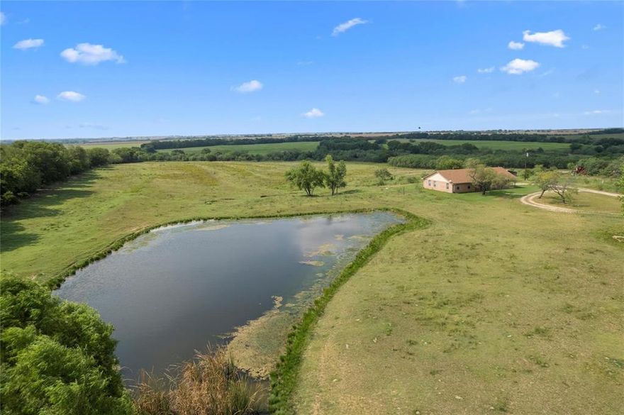 This 52.5-acre property is a true gem, offering endless possibilities for outdoor enthusiasts and those looking for a peaceful retreat. The land itself is a standout feature, with a stocked fishing tank perfect for anglers or as a reliable water source for cattle and horses. A seasonal creek winds its way through the property, splitting into two branches and creating a wildlife haven. Deer, turkey, dove, and even the occasional hog can be spotted enjoying the shaded areas along the creek.The home, while cozy, has its own unique charm. The wood-burning stove in the living room adds a warm, rustic touch, making it the perfect spot to relax and unwind. The kitchen is well-equipped with ample cabinets and workspace, and the spacious laundry room keeps things practical. The garage not only provides secure parking but also includes a storm shelter rated to withstand Texas tornadoes, ensuring safety and peace of mind.
But that's not all—this property also boasts a 23x25 shop that's been spray-foamed and equipped with heating and cooling. Whether you're looking for a space to tinker with projects, store equipment, or even set up a workshop, this shop offers the flexibility to suit your needs.
With its sprawling acreage, abundant wildlife, and functional structures, this property is a rare find. Whether you're looking for a peaceful escape, a place to raise animals, or a promising investment opportunity, this land is brimming with potential.