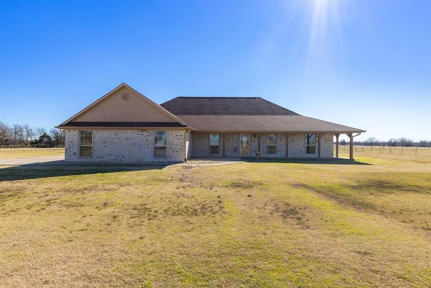 This 4 bedroom, 2.5 bath brick home, with over 3,000 square feet, comes with 2 living areas, 2 dining areas, and a game room. Sit on the wraparound front porch and enjoy the country views at the end of a long driveway on Ag-exempt 41.21 acres! Step inside through a foyer hall where the formal dining is off to the left or easily use the room as office space. A wall of windows floods light into the main living room that is attached to a breakfast area with a door that gives you access to the covered back patio. The kitchen includes an island, double ovens, breakfast bar, cooktop, and walk-in pantry. A family room is located next to an extra large game room! Or you can close off the game room to make a 5th bedroom or convert the family room and game room into a mother-in-law suite. In addition, you also have three guest bedrooms which are split from the primary ensuite. Relax in the spacious primary bedroom which has an abundance of windows, a jetted soaking tub, separate shower, separate vanities, and a walk-in closet. A barn gives you extra storage for farm equipment or hay while 2 ponds provide recreational fun or water for livestock. Other items are a 2-car garage, recessed lights, and crown molding. Can be subdivided. With a great floor plan layout and acreage, you can create the dream property you've always wanted!