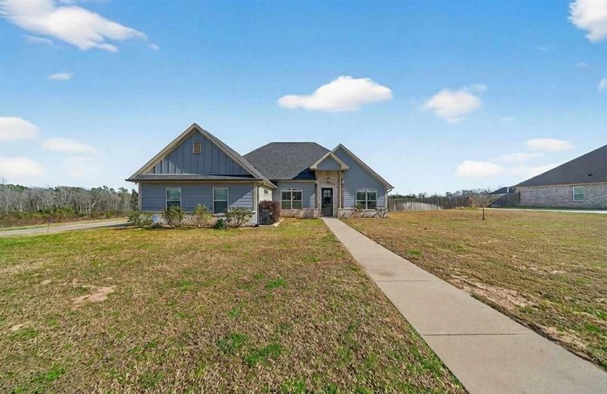 Stunning Modern Farmhouse on a Spacious 0.59-Acre Lot!
Welcome to this beautifully crafted single-story modern farmhouse offering 1,947 sq. ft. of elegant living space. Built in 2019, this 4-bedroom, 2-bath home perfectly blends charm, comfort, and modern convenience. The home is situated in a beautiful, secluded neighborhood on a private road with a Tyler address but tucked right in Lindale, in the highly rated Lindale ISD. Step inside through the grand vaulted entry adorned with a chandelier, decorative wood beam accents, and matching brick columns that echo the home’s floor-to-ceiling brick fireplace — the centerpiece of the open-concept living area. The vaulted ceiling with exposed wood beam, custom plantation shutters throughout with lifetime warranty, and ceiling fans in every room create a warm and inviting atmosphere throughout. The gourmet kitchen is a chef’s dream, featuring an oversized granite island, stainless steel appliances, display glass cabinetry, an extra-large walk-in pantry, and a custom wood-paneled ceiling that adds a touch of rustic sophistication. Retreat to the private primary suite, highlighted by a coffered, wood-beamed ceiling, luxurious spa-style bath with jetted tub, granite double-sink vanity, and a walk-in shower. Enjoy the extra large walk-in closet with a built-in dresser, abundant shelving, cubbies and convenient easy access door that leads right into the laundry room. Each bedroom offers built-in closet shelving for optimal storage and organization, ceiling fans, ample room and natural light. The two car garage is aesthetically situated at the side of the home giving this house lovely curb appeal. Enjoy peaceful evenings on your expansive lot with plenty of room for outdoor entertaining, gardening, or simply soaking in the serene surroundings. The fenced backyard is a plus! This meticulously maintained home combines thoughtful design, quality craftsmanship, and timeless farmhouse appeal — truly a must-see!