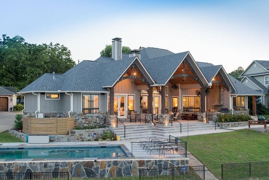 Post-card perfect views and uncompromising quality custom built Green Home by Tracy Mitchell Homes. Enter the foyer and see wood arches framing miles of open water to the incredible lakeside fenced yard with crystal blue pool, expansive outdoor living areas and boathouse. This lake escape features soaring ceilings flooded with natural light, an open layout providing ample space for entertaining. Spacious eat-in gourmet kitchen, stainless steel appliances, ebony honed granite leather finish countertops, 42”  French door refrigerator, 36” 6 burner gas stovetop, under counter ice maker and wine refrigerator, double oven, warming drawer, farm sink graces expansive island, and large dining area with lake views.  Main bedroom suite with ensuite luxury bath, safe room in master closet, extra room with built-ins and Murphy bed, 3 guest suites with ensuite bathrooms. Upstairs media room with surround sound, snack bar and full bath.  Heat and cooled oversized garage with lift to attic.