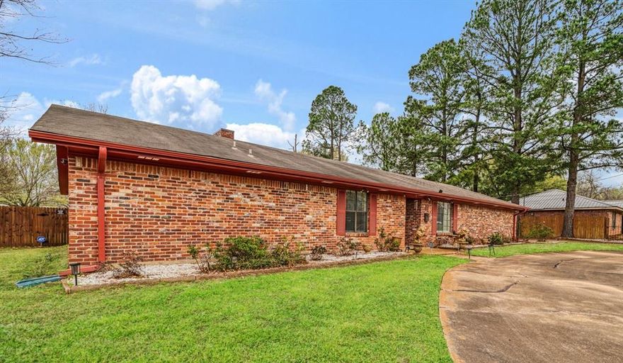 Not often you find a property like this within the city limits of Paris, Texas!   Almost 3000 square feet of living space on half an acre!  This 3 bedroom, 2 bath with 2 living areas, 2 dining areas and a flowing floor plan is hard to beat.  The property offers a homeowner both space and convenience.   Step inside to find a formal dining room, or home office, you decide and then into the spacious living room with fireplace focal point and exceptional natural light.  Kitchen is ready for the best of cooks with double oven, stainless appliances and breakfast bar.  Primary suite is spacious with well-appointed full bath and walk-in closet. 2 additional bedrooms feature large closets and easy access to the hall bath.  Like to entertain?  No worries, as the 30x28 den is a perfect place to add additional seating or game tables.  Built in bookcases for storage, a wet bar with bar top seating and media setup. Furthermore, enjoy morning coffee or afternoon relaxation on the open patio looking out onto the fully fenced backyard.  Centrally located for easy access to all the city amenities.  Property features attractive wrought iron fencing with gates on both ends of the circular driveway.