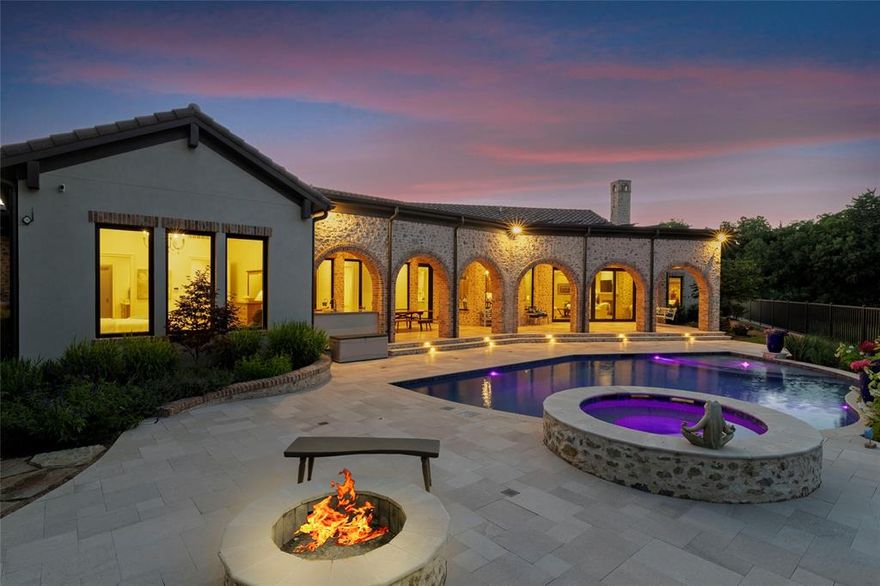 Nestled in the prestigious gated community of Stony Brook, this custom SCH award-winning Mediterranean estate offers 4,501 square feet of refined living space in a serene cul-de-sac backing to a greenbelt with no neighbors on one side. Designed for both elegance and comfort, the home features soaring ceilings, hand-scraped hardwood floors in living areas, and tile finishes throughout each of the six bathrooms. Four spacious bedrooms each include an ensuite bath, while a thoughtfully designed fourth garage bay with full bath accommodates an RV or flexible use.  
The open-concept kitchen and living area is the heart of the home, anchored by a large center island with breakfast bar and hidden storage. Culinary enthusiasts will appreciate the 7-burner gas cooktop, vent hood, built-in counter-depth refrigerator, and dishwasher. A separate prep kitchen with pantry, double Wolf ovens, microwave, and warming drawer ensures effortless entertaining. The formal dining room provides an elegant setting for gatherings, while the eat-in area overlooks the private backyard oasis.  
Outdoor living is elevated with a heated pool (with cover), heated spa, and tranquil water feature. The covered patio includes a fully equipped outdoor kitchen with commercial vent hood over the gas grill, complemented by a fire pit and convenient half bath. Modern amenities include owned solar panels with a 25-year transferable warranty and a smart home system controlling lighting, sound, security, fire suppression, and climate.  
The extra-deep three-car garage offers two prewired EV charging ports, while the fourth bay is designed for RV storage. Zoned for Keller ISD with open enrollment for Carroll ISD, this home combines award-winning craftsmanship, advanced technology, and resort-style amenities in one of the area’s most desirable communities. A rare opportunity to experience luxury, privacy, and convenience in perfect harmony.