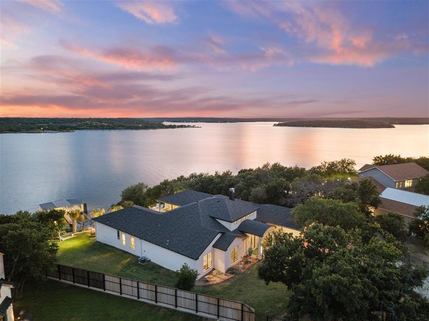 THIS IMMACULATE LUXURY LIVING CUSTOM BUILT COASTAL MODERN Lakefront home is ready for you to enjoy all the summer activities on a Beautiful Texas Hill Country Lake. This property is located in the central Texas area of the state on LAKE BROWNWOOD. The lake is currently full at Spillway level and the property has approximately 27 feet of water depth. This modern, architecturally designed custom-built home is only 3 years old. As soon as you enter this home the view of the lake is to be seen overlooking the infinity edge swimming pool. This home features 4,445 square feet of heated and cooled living area with 5 bedrooms, 5 bathrooms, walk-in closets, split bedroom arrangement. The massive living areas with high ceilings features a gas lit wood burning fireplace, 2 dining areas, breakfast area, large island with seating, a stone countertop, with a dishwasher, disposal, ice maker, sink, and lots of storage. The kitchen boasts custom cabinets floor to ceiling, a large gas 5 burner cookstove, built-in oven and microwave, stainless double refrigerator and freezer, indirect lighting, and a wine cooler. Modern tile flooring is installed throughout the home with carpet in the bedrooms. A bedroom on each side of the house has a view of the lake and the infinity edge swimming pool. The covered patio features a gas burning fire pit, 2 decorative gas bowl pits, a gas grill, and a small refrigerator that all sits on a stamped and stained concrete flooring. The infinity pool is not covered and features tow water depths with easy steps into the pool. The covered patio has large glass folding doors that open into the den and living area of the house. The 2-car garage is 817 square feet of area and is cooled with a mini-split AC unit. The garage has attic access, a large utility room with washer and dryer connections, an irrigation system from the lake, filtration water system for the house and treated rural water is coming soon to the house. Easy access to the 2 slip, boat dock.