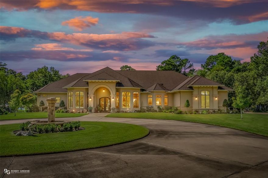 This breathtaking Cross Lake waterfront estate defines luxury living at its finest, offering a rare combination of architectural elegance, craftsmanship, and serenity on just under two acres. Designed to maximize every stunning lake view, this custom-built home blends sophistication with comfort and an effortless flow for entertaining. The chef’s kitchen is a dream with a gas cooktop, abundant cabinetry, granite counters, built-in desk, and an adjoining bar area complete with wine fridge, ice maker, sink, and display cabinetry. Two living areas create inviting spaces for relaxation and gatherings, including one with a custom gas fireplace and built-ins. The formal dining and breakfast areas provide the perfect setting for any occasion. The primary suite is a true retreat, featuring dual walk-in closets and a spa-like bath with a large walk-in shower and two separate vanities. Each guest suite includes its own ensuite bath and walk-in closet, offering privacy and comfort. A spacious study adds versatility, while the oversized laundry room is equipped with extensive storage and workspace. Custom plantation shutters, hardwood floors, spray foam insulation, and a built-in surround sound system enhance both style and efficiency. Outdoor living is equally spectacular with a covered lanai, sparkling inground pool, outdoor kitchen with grill, dual burners, sink, and refrigerator—ideal for lakeside entertaining. A private pier and boat slip provide direct access to the water, while a peaceful side courtyard adds an intimate touch. From morning coffee overlooking the lake to sunset gatherings by the pool, every detail of this home invites you to relax, entertain, and live beautifully. This property embodies timeless sophistication and offers a rare opportunity to own one of Cross Lake’s most extraordinary homes.