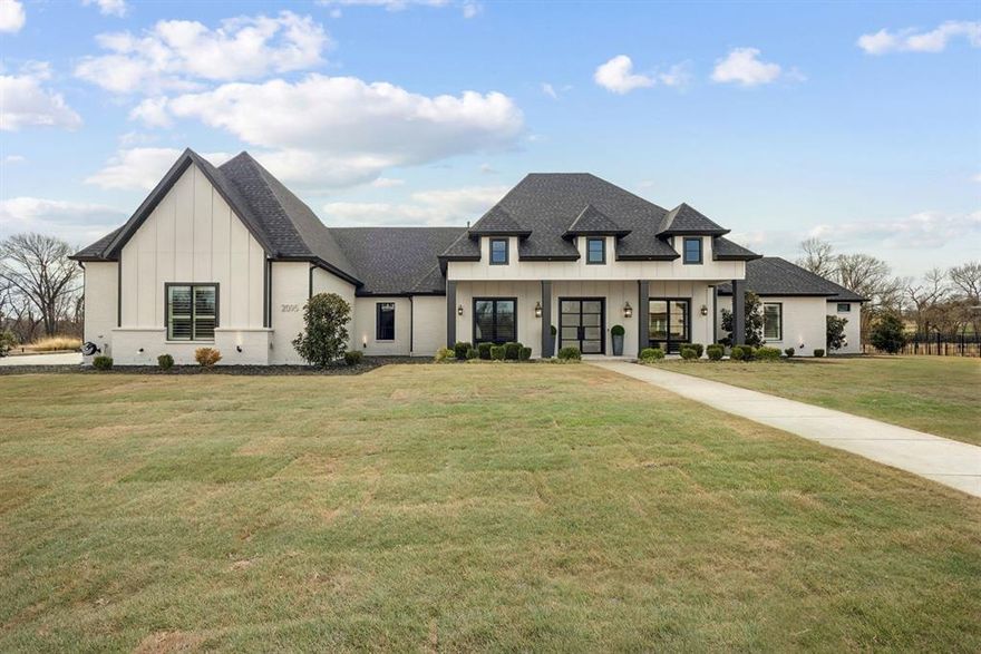 Built in 2022 by award-winning, family-owned Dave R. Williams Homes, this exceptional 4,687 square foot, north facing single story estate sits on a premium 1.5 acre lot in gated Hidden Creeks Pointe and backs to a tranquil greenbelt and creek setting. Grand double iron doors open to a light filled, open concept design with wood beamed ceilings, nailed down hardwoods, plantation shutters, designer lighting, and custom built ins. The chef’s kitchen is equipped with Sub Zero and Wolf appliances, double ovens, Bosch dishwasher, pot filler, an oversized island with built in Scotsman ice maker, and a spacious butler’s pantry. A thoughtfully split plan offers 4 bedrooms, 4 full baths and a half bath off the game room with direct access to the pool deck. Additional highlights include a home office with closet, ethernet, TV outlet and floor plug, game room, fully-loaded media room with wet bar, private gym with direct pool access, and a Texas basement for storage and HVAC access. The primary retreat features an electric fireplace, coffee bar, spa bath with separate vanities, dual walk-in closets, and additional laundry hookups in main closet. Smart-home and peace-of-mind upgrades include whole home ethernet plus multiple wireless access points, 6 to 8 exterior cameras, motorized shades, Orkin pest and mosquito proofing, and a reinforced storm shelter. A whole-home Generac generator, water treatment and softener system, and under sink reverse osmosis filtration ALL convey. Outdoor living shines with a covered patio, heated pool and spa, kitchen with grill, griddle, refrigerator, and sink, fireplace with TV outlet and speakers, turf play areas, fenced dog run, and an oversized 4 car garage with epoxy floors and built in storage. Located in Celina’s ETJ, which is outside Celina's city limits, the estimated 2025 effective tax rate is roughly 1.44% per public records, meaning materially lower annual carrying costs, and with no MUD or PID for additional long-term savings!